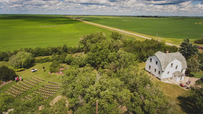 Aerial view of a farmyard wedding ceremony surrounded by fields